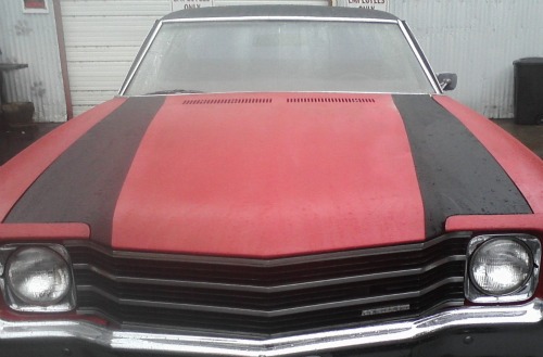 Ford El Camino with spray paint repair and black racing stripes painted on it